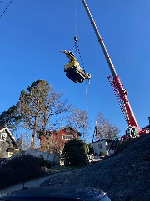 Borrmaskin transporteras av lyftkran